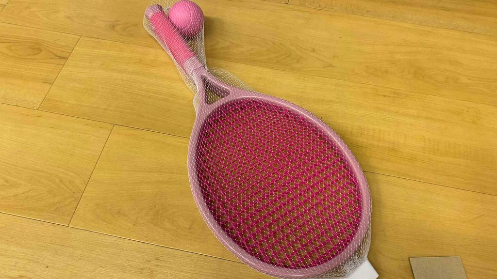 Auf dem Boden liegt ein Paar getestete Tennisschläger für Kinder in der Farbe Rosa. 