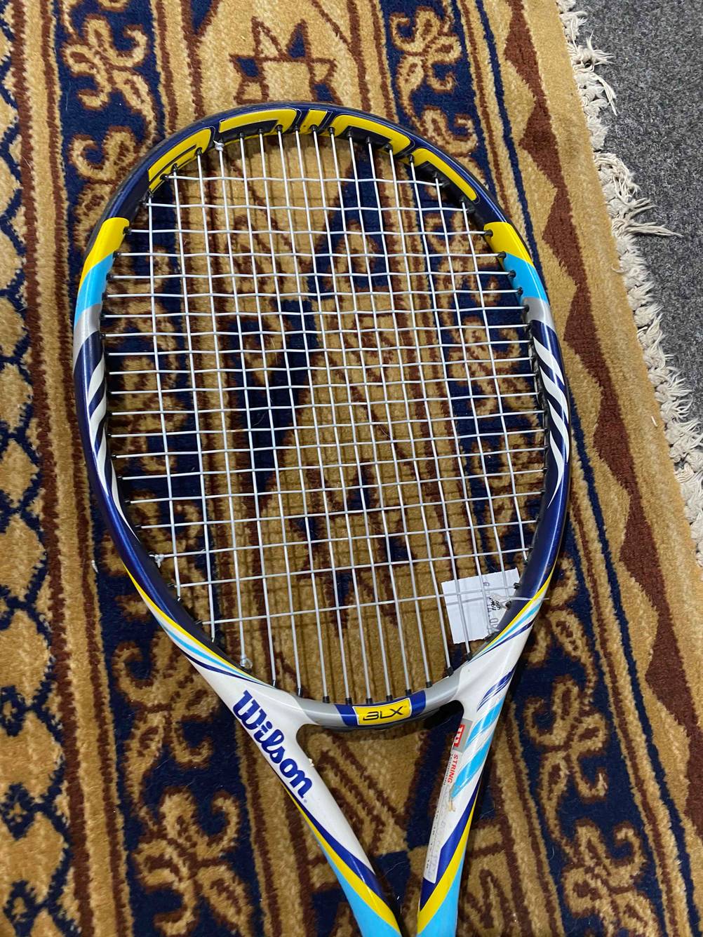 Auf dem Teppich liegt ein getesteter Tennisschläger.
