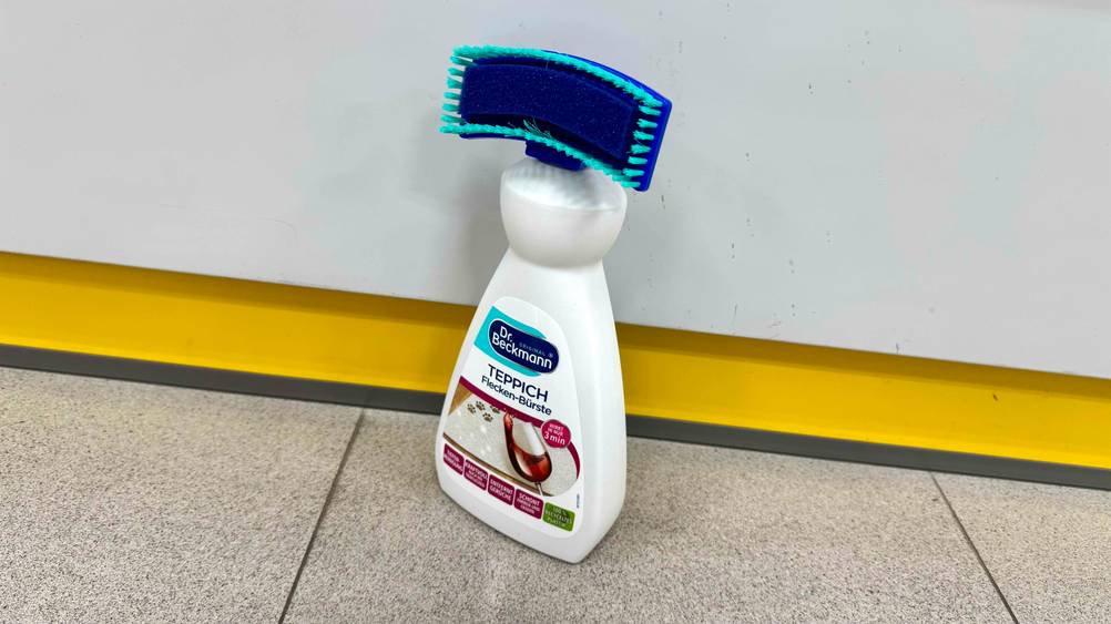 Auf dem Boden steht leicht seitlich eine Flasche des getesteten Teppichshampoos.