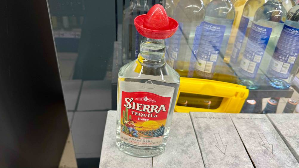Eine Flasche des getesteten Tequila-Blanco steht auf Kartons vor einem Regal mit Flaschen.