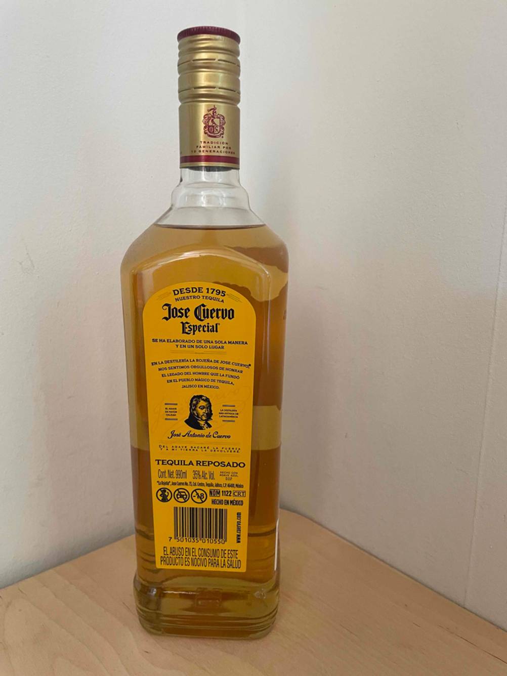 Rückseite einer Flasche des getesteten Tequilas vor einer hellen Wand.