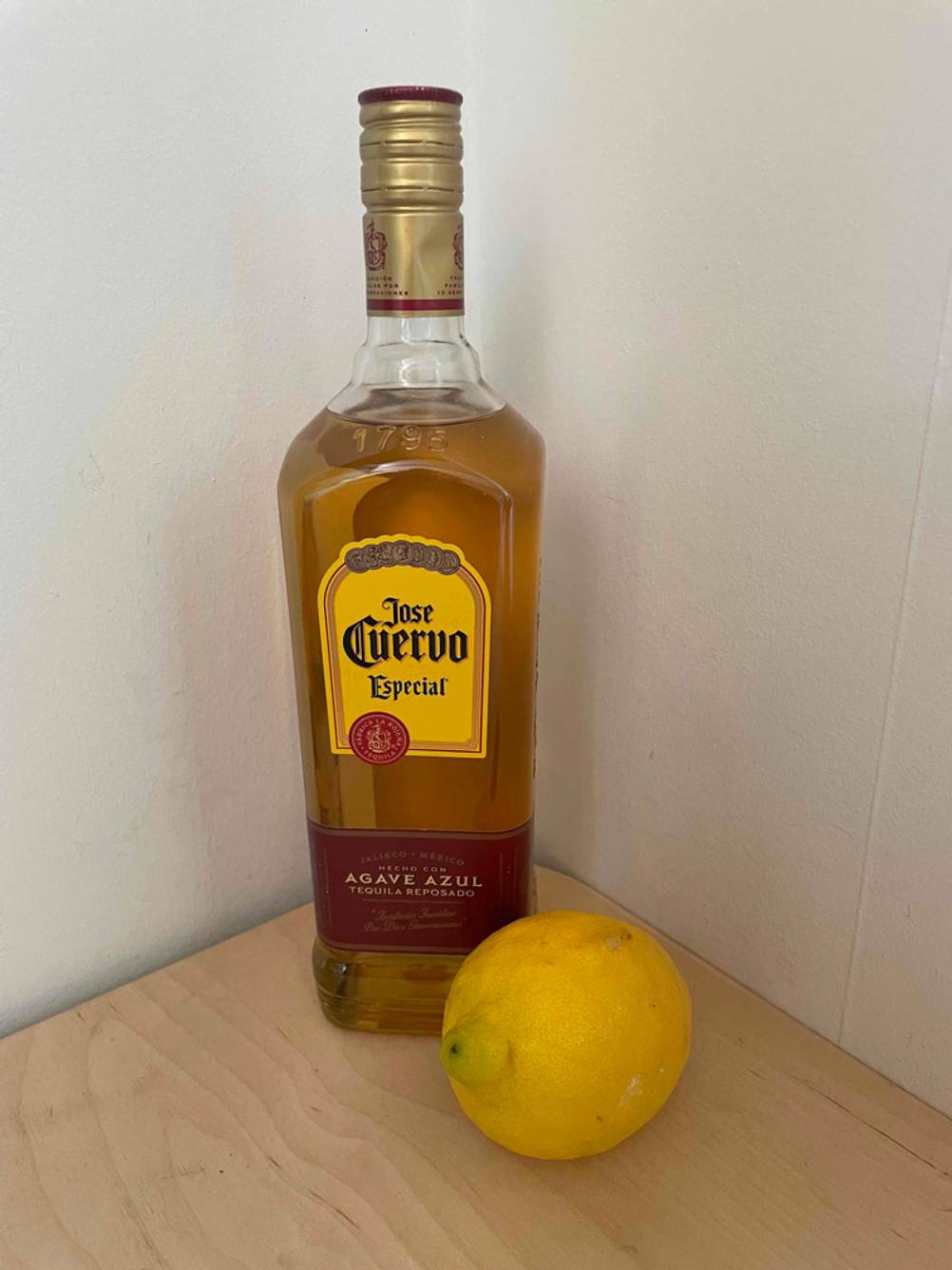 Eine getestete Tequila-Flasche steht neben einer Zitrone. 