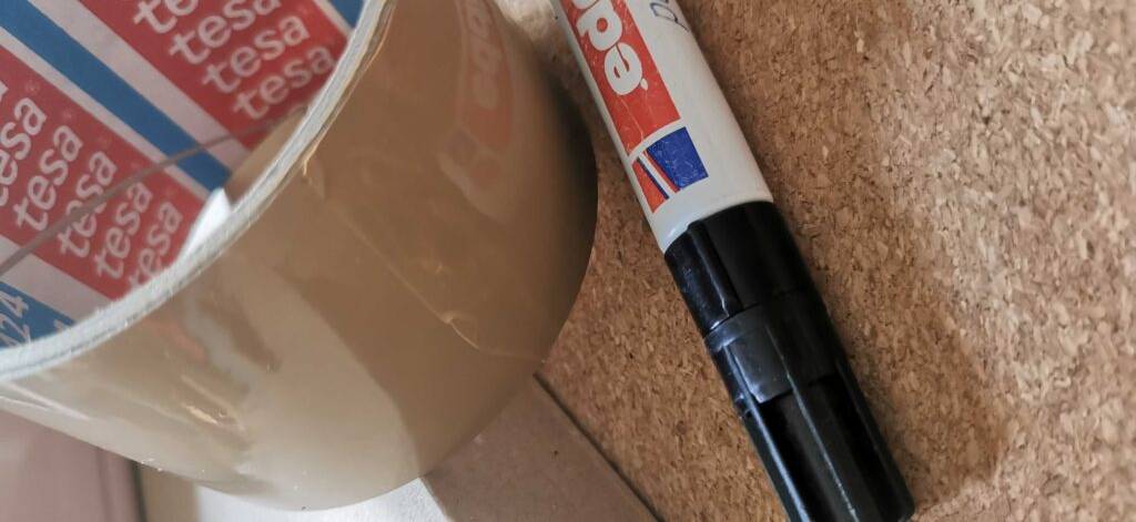 Paketklebeband im Test: Nahblick auf das braune Klebeband, das hinter einem Eddingstift liegt.