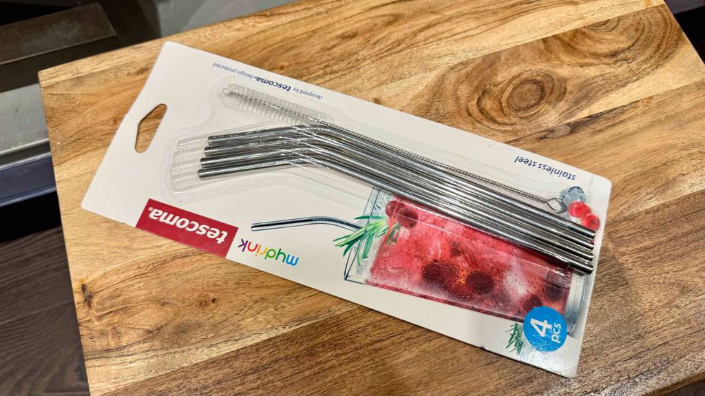 Eine Packung mit vier Edelstahl-Strohalmen im Test liegt auf einer Holzfläche.