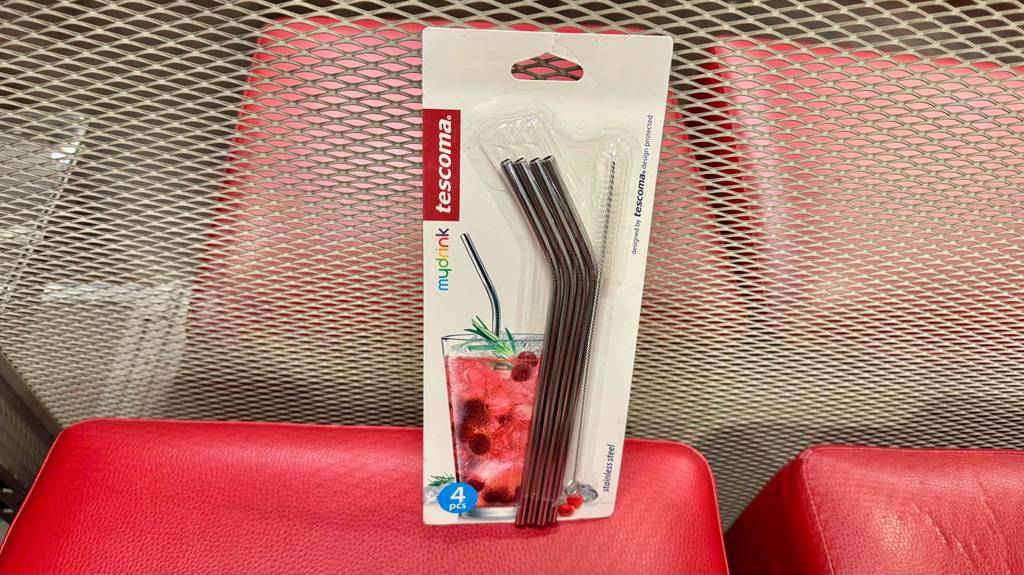 Eine Packung mit sieben getesteteten Edelstahl-Strohalmen steht auf einem roten Hocker.