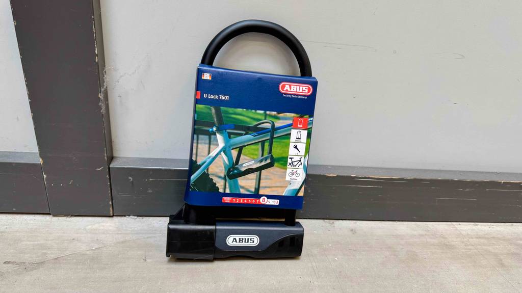 Abus Bügelschloss Test: Ein Abus-Bügelschloss in der Verpackung lehnt an einer weißen Wand.