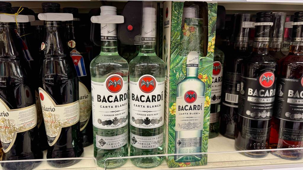 Mehrere Flaschen mit getestetem Bacardí stehen in einem Verkaufsregal neben weiteren Spirituosen.