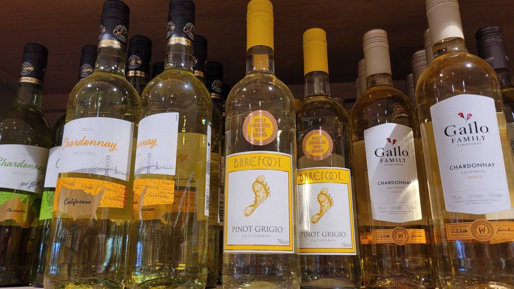 Barefoot-Wein im Test: Mehrere Flaschen mit Schraubverschlüssen stehen nebeneinander auf einem Weinregal.