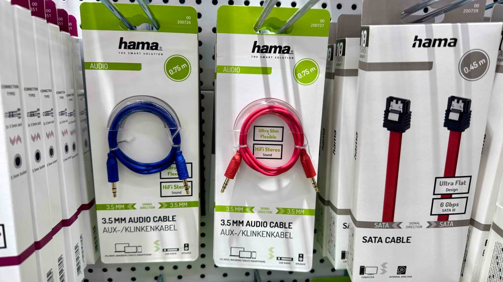 Im Test: Ein rotes Aux-Kabel in der Verpackung hängt neben weiteren Kabeln an einem Verkaufsregal.