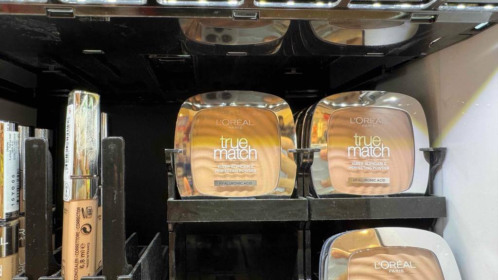 Eine Dose mit getestetem L'Oréal-Puder steht neben weiteren Puderdosen in einem Verkaufsregal.