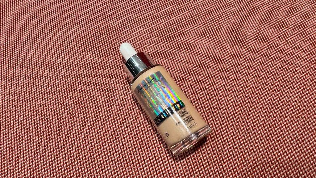 Maybelline-Make-Up getestet: Eine Flasche inklusive Pipette liegt auf einem rosafarbenen Untergrund.