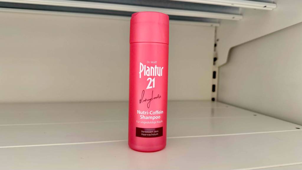 Plantur-Shampoo-Test: Eine rote Kunststoffflasche mit Nutri-Coffein-Shampoo steht in einem weißen Regal.