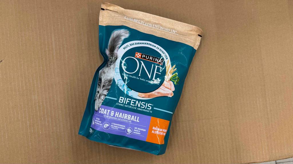 Getestetes Purina-Trockenfutter für Katzen in der wiederverschließbaren 750-g-Tüte liegt auf einer braunen Pappe.