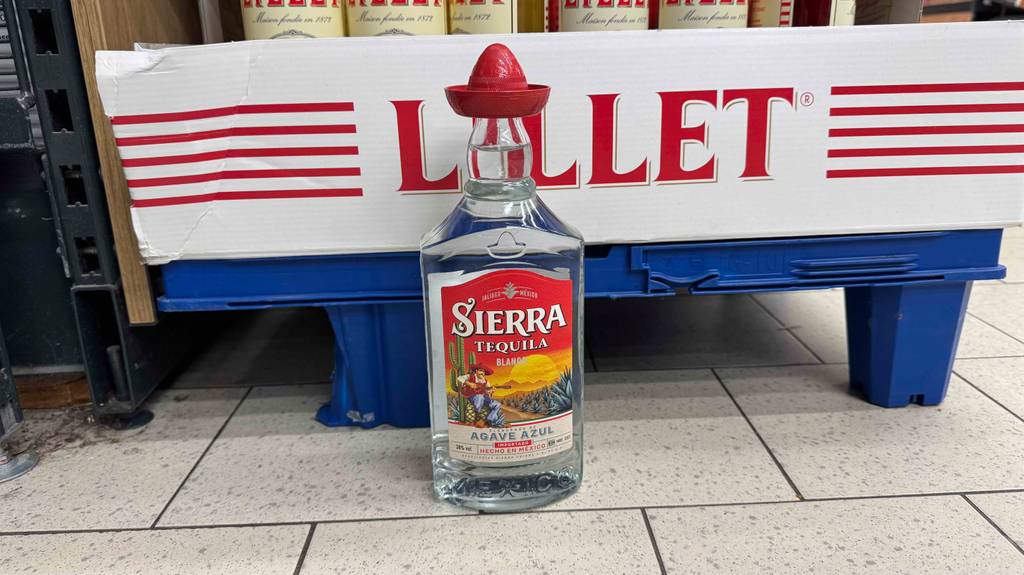 Eine Flaschen mit Sierra-Tequila im Test steht vor einem blauen Hintergrund.