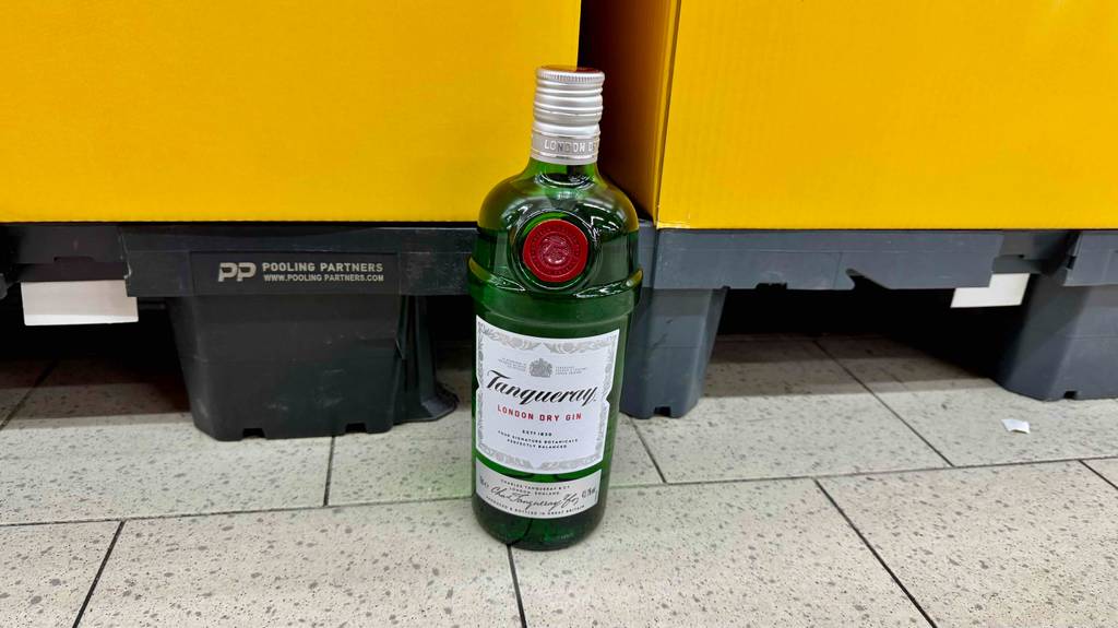 Tanqueray-Gin im Test: Eine grüne Flasche mit Schraubverschluss steht vor einem gelben Hintergrund.
