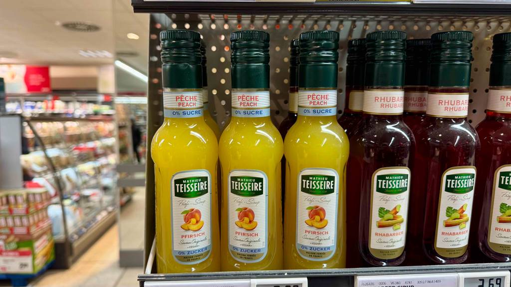 Getestet: Teisseire-Sirup in der Flasche mit gelber Flüssigkeit steht neben weiteren Sirupsorten auf einem Verkaufsregal.