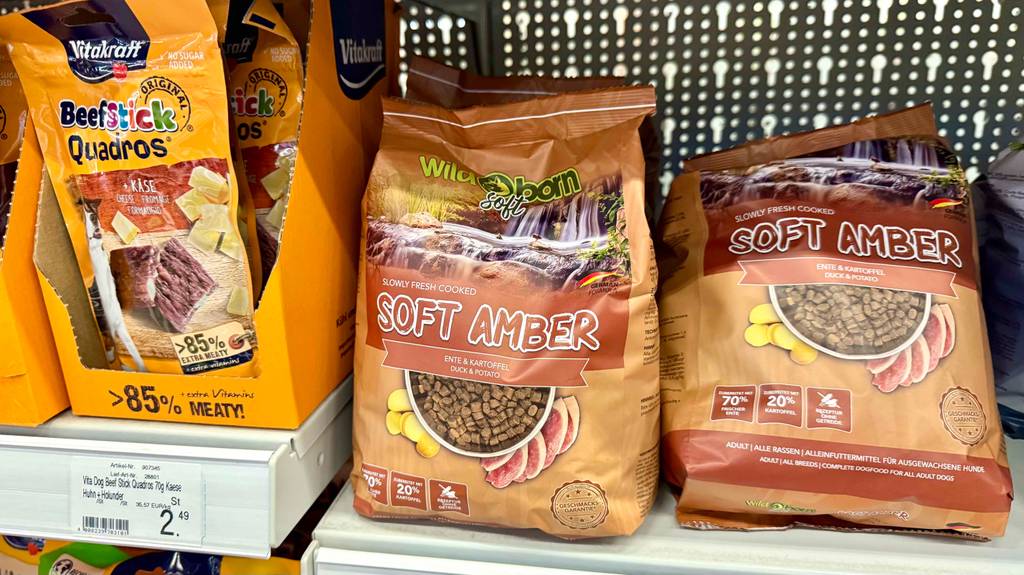 Getestetes Wildborn-Hundefutter in einer braunen Packung für Trockenfutter steht auf einem Verkaufsregal neben weiteren Sorten Hundefutter.
