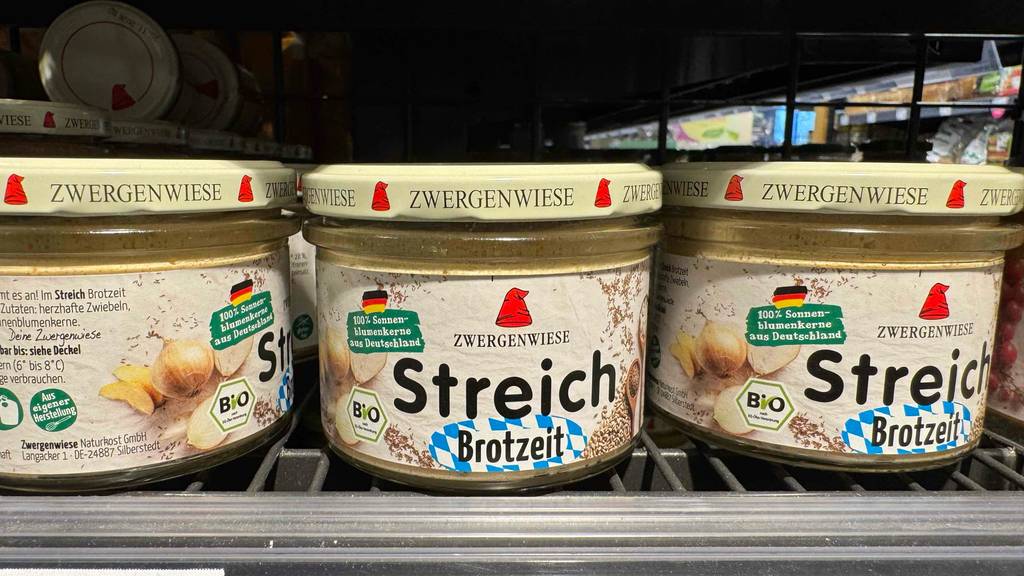 Zwergenwiese Brotaufstrich im Test: Mehrere Gläser mit Schraubverschlüssen stehen nebeneinander im Verkaufsregal.