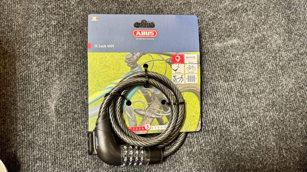 Abus-Zahlenschloss im Test: Ein Modell mit 100 Zentimetern Länge liegt auf einer grauen Matte.