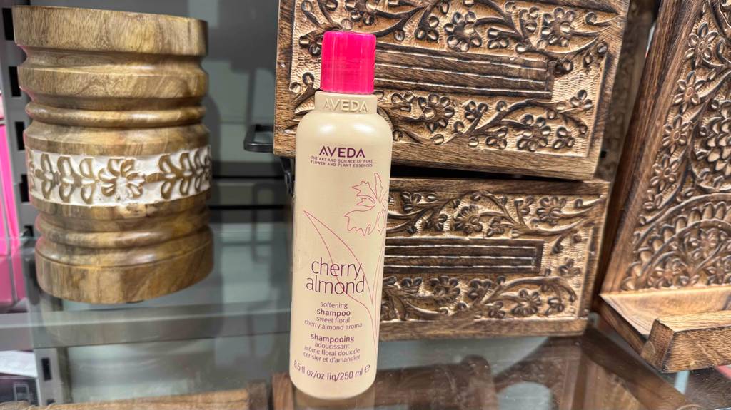 Eine beigefarbene Kunststoffflasche mit Aveda-Shampoo im Test steht auf einem Verkaufsregal.