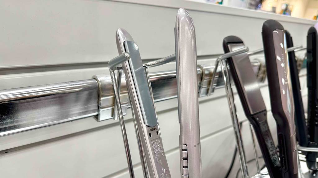 Das Babybliss-Glätteisen im Test ist neben weiteren Glätteisen auf einem Regal ausgestellt.