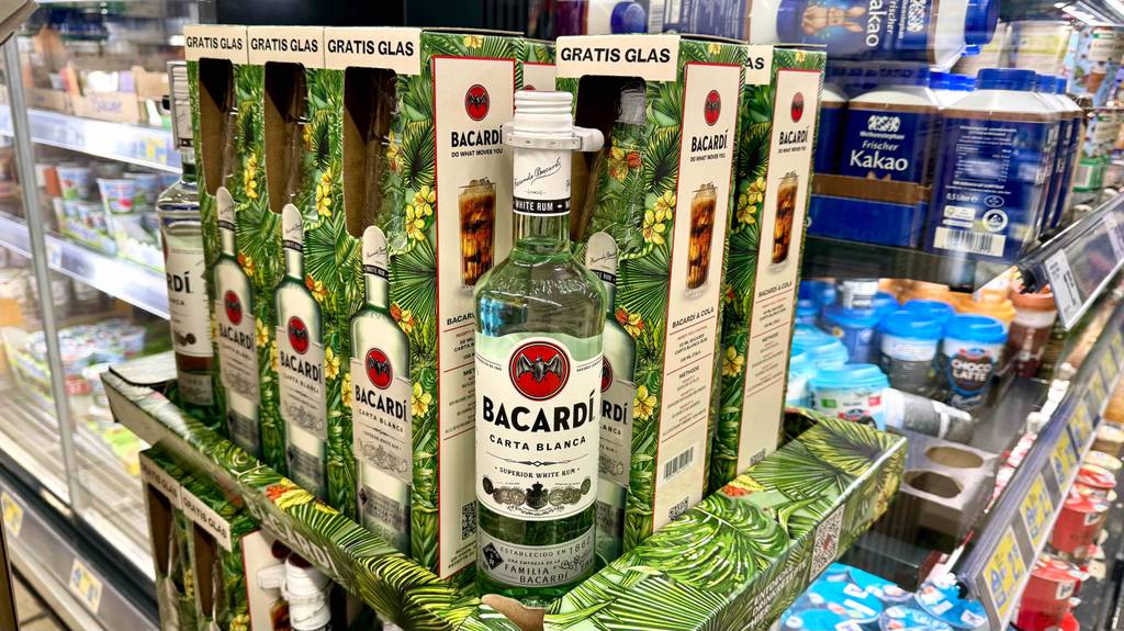 Eine Flasche Bacardí im Test inklusive Geschenkverpackung steht auf einem Ausstellungspodest im Supermarkt.