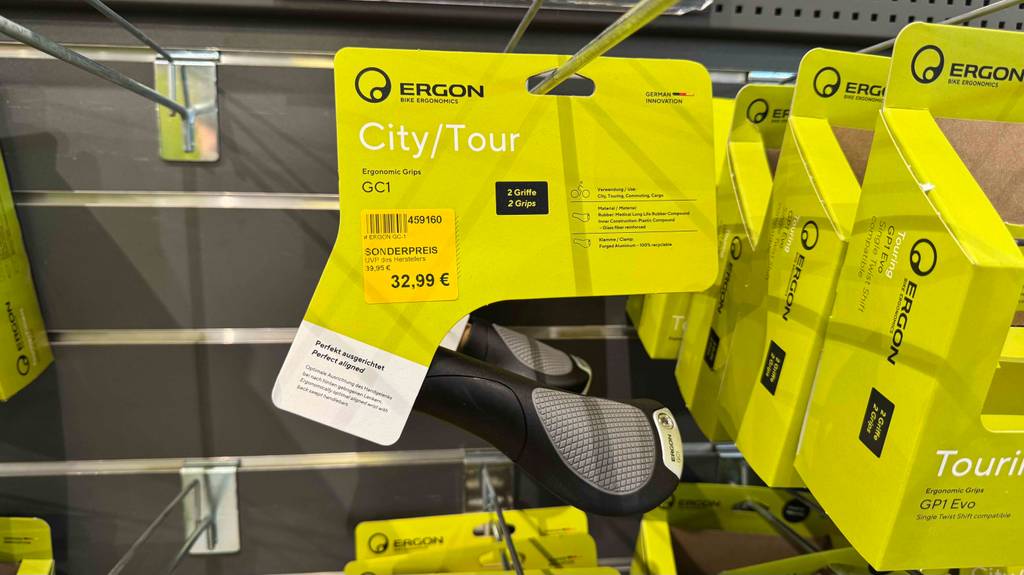 Der getestete Ergon-Griff in Schwarz-Grau hängt neben weiterem Fahrradzubehör an einem Verkaufsregal.