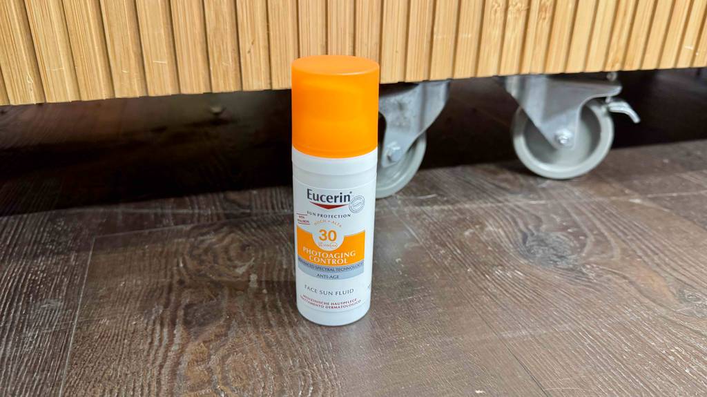 Eine getestete Eucerin-Sonnencreme mit Lichtschutzfaktor 30 steht innerhalb der Kunststoffflasche vor einem Verkaufsregal.