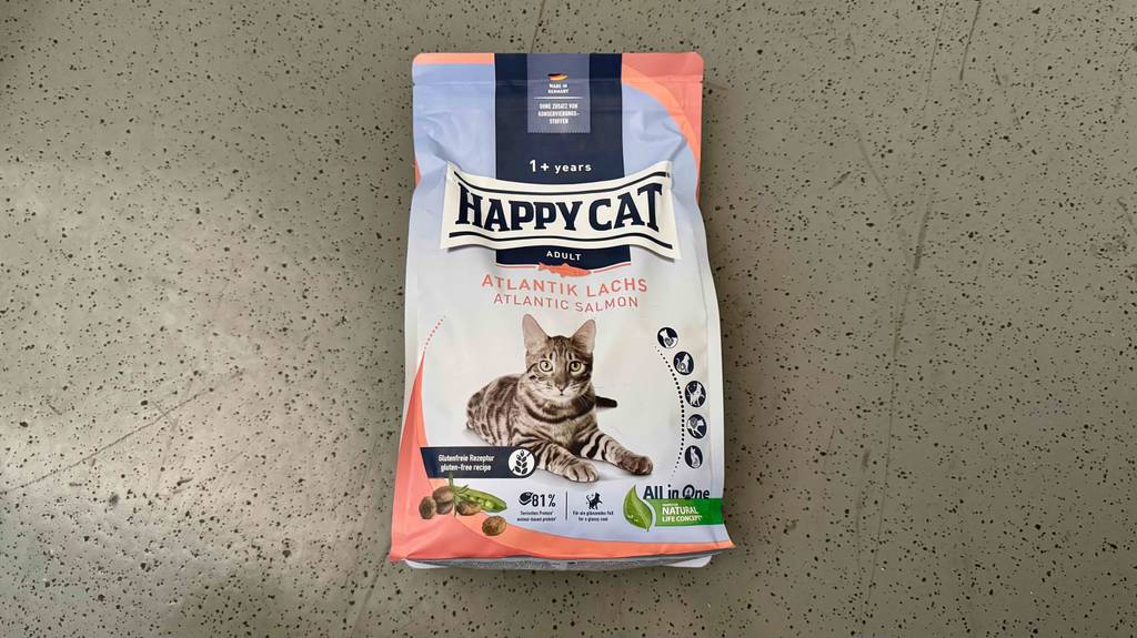 Eine Portionstüte mit getestetem Happy Cat Katzenfutter liegt auf dem Boden.