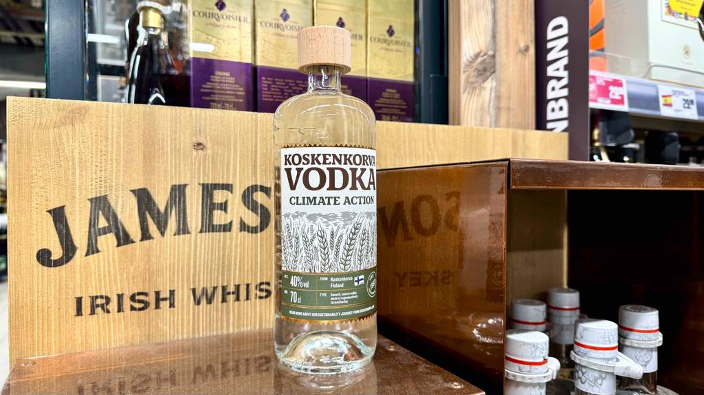 Getesteter Koskenkorva-Vodka in der Flasche steht vor weiteren Flaschen mit Alkohol auf einer Ausstellungsfläche.