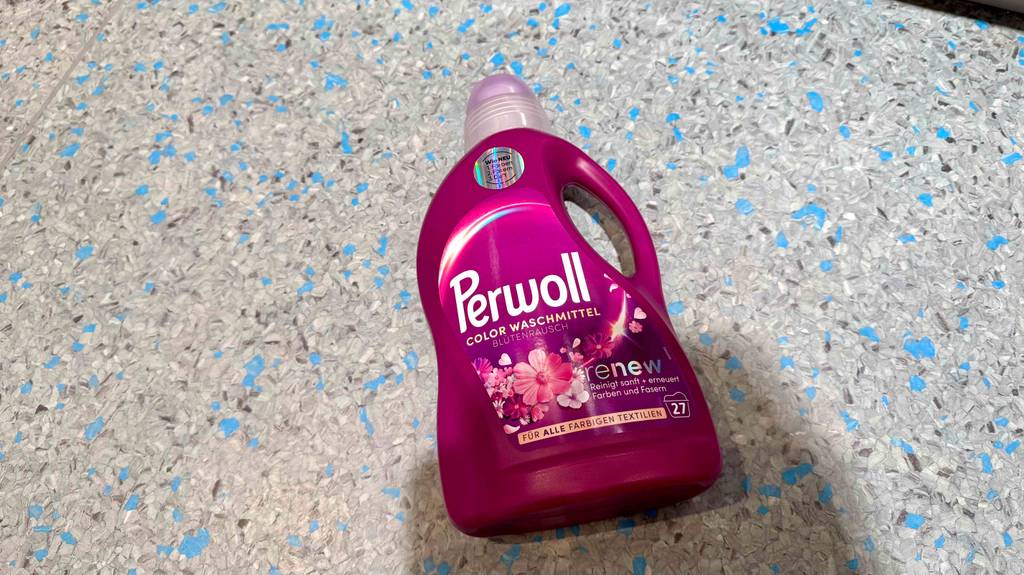 Test: Ein Perwoll-Waschmittel in der pinkfarbenen Flasche liegt auf dem Boden.