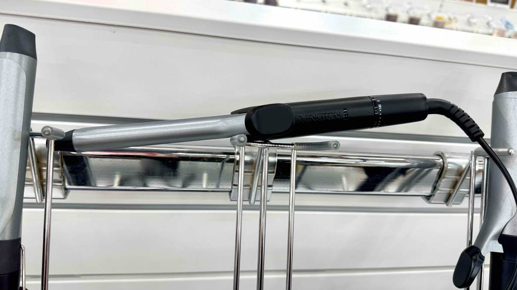 Ein getesteter Remington-Lockenstab liegt auf einem Ausstellungsregal im Verkaufsbereich.