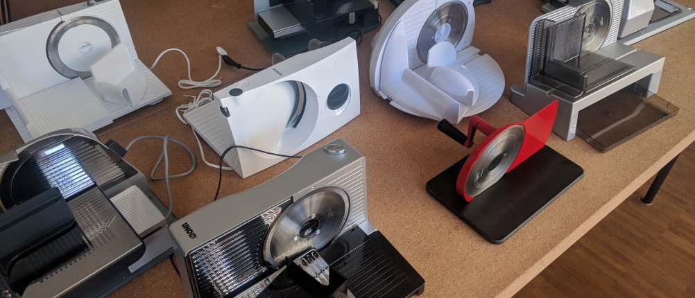 Verschiedene elektrische und manuelle Allessschneider auf einem Tisch