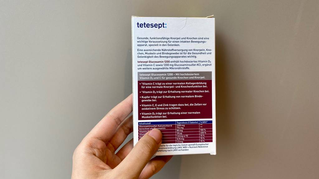 Im Test: Rückseite einer Packung tetesept Glucosamin 1200, die von einer Hand gehalten wird.