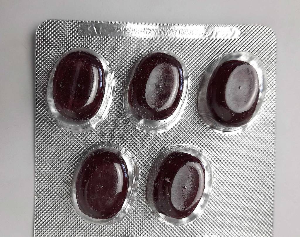 Detailansicht von mehreren Pastillen von Mittel gegen Reizhusten im Test im Blister.