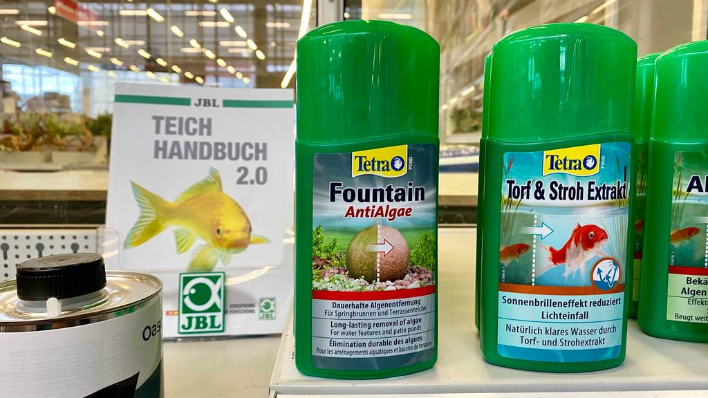 Dauerhafter Algenentferner im Test: Eine grüne Tetra Kunststoffflasche steht auf einem Verkaufsregal inmitten weiter Reinigungsprodukte.
