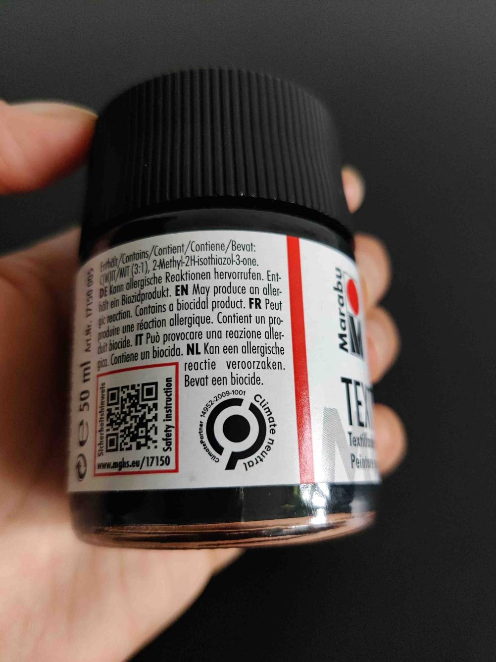 Eine Hand hält eine Dose der Textilfarbe im Test mit Informationen auf der Rückseite.