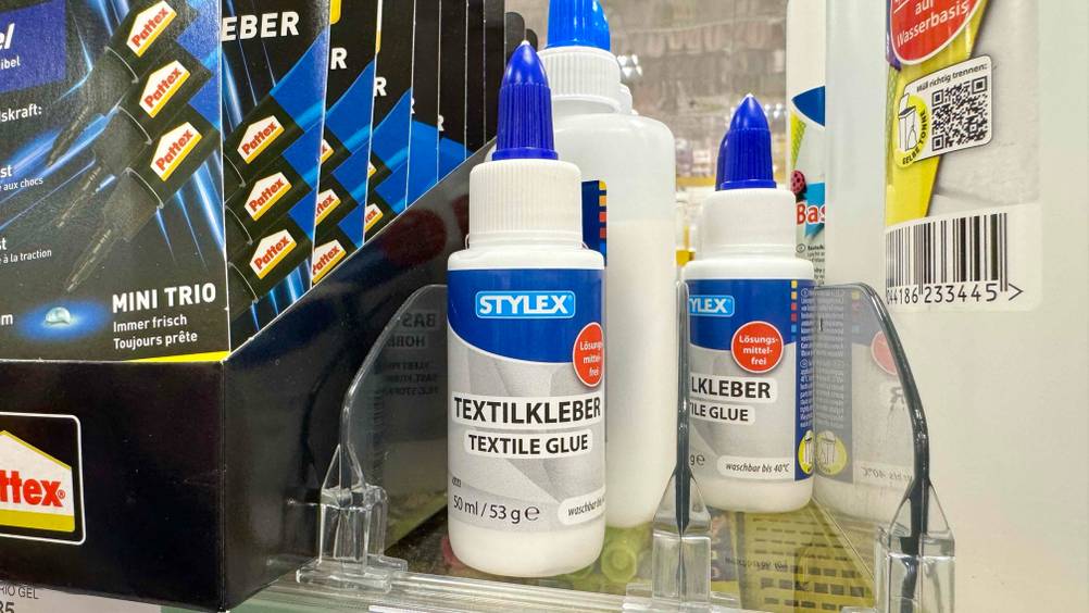 Mehrere Flaschen des getesteten Textilkleber im Verkaufsregal.