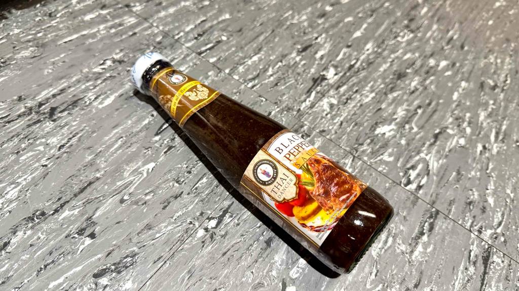 Blick von oben auf eine am Boden liegende Flasche getestete Pfeffersauce.
