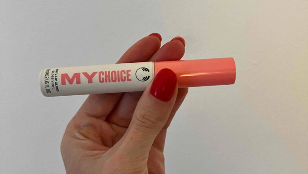 Ein rosa getesteter Lip-Plumper, von mehreren Damenfingern gehalten.