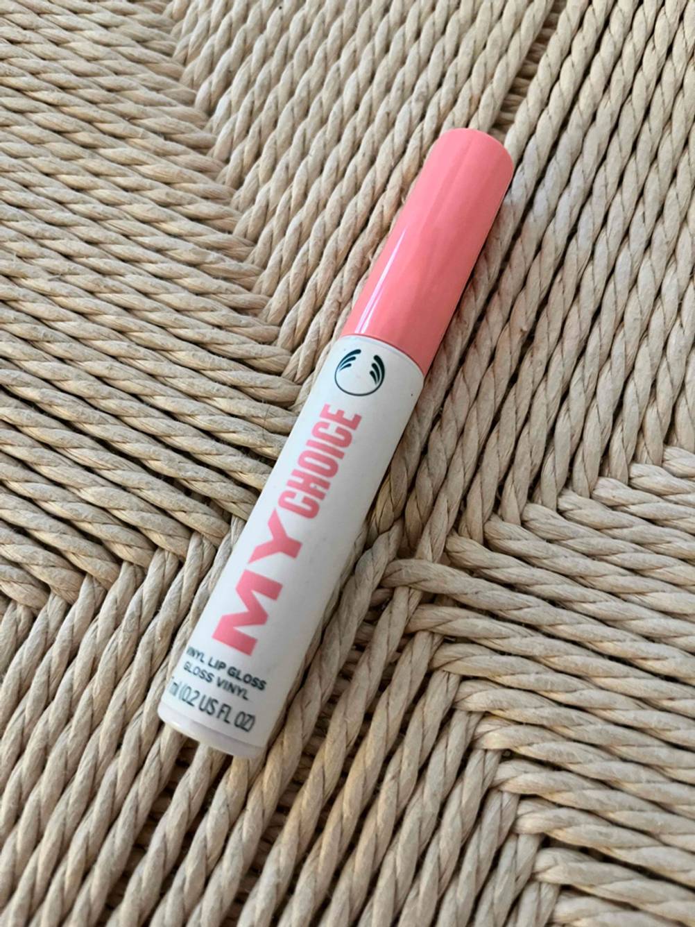 Im Test: Lip Plumper My Choice liegt schräg auf Rattanfläche.