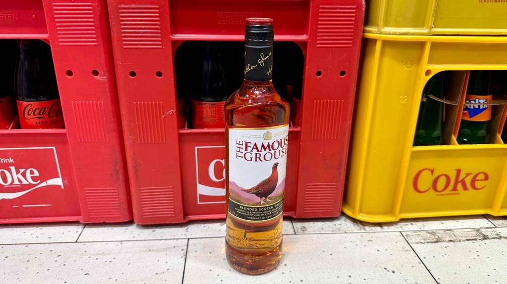 Blended Whisky-Test: Eine Flasche steht vor Getränkekisten.