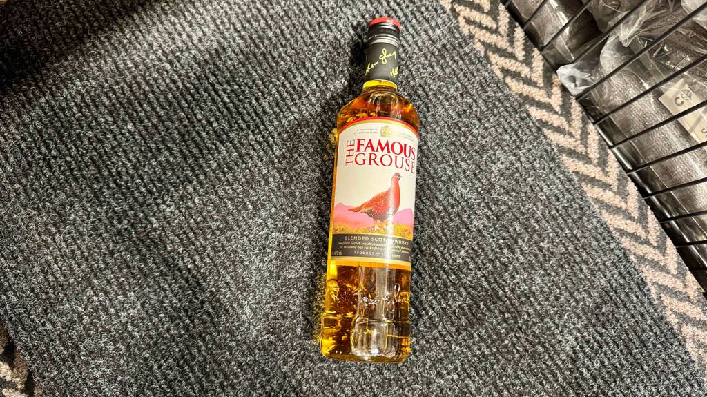 Eine Flasche getesteter Blended Whisky liegt auf einer Fußmatte.