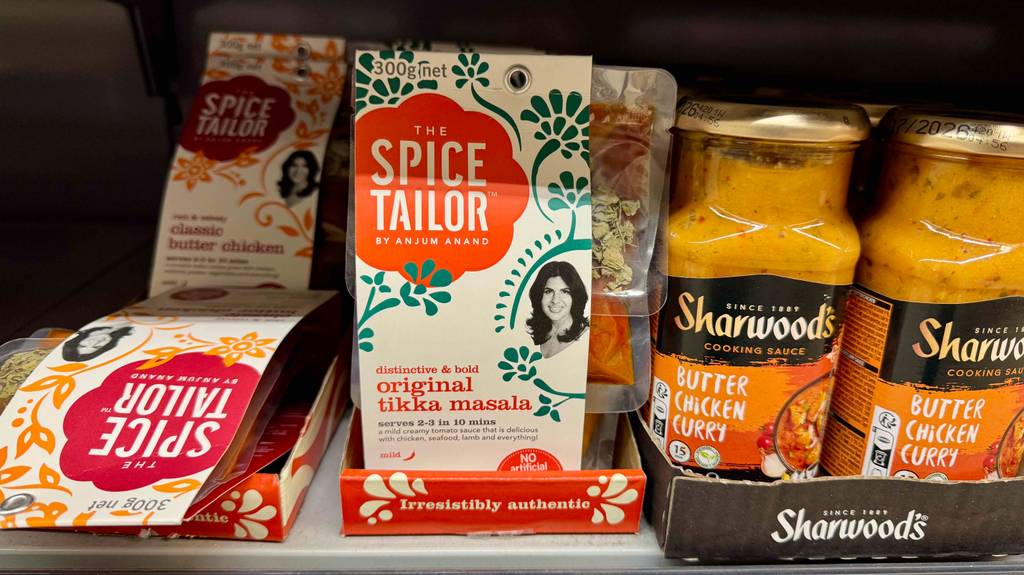 Tikka-Masala-Paste im Test: Mehrere Packungen stehen zwischen anderen Produkten in einem Regal.