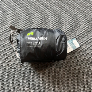 Die vollständig verpackte Therm-A-Rest Trail Lite liegt auf einem Teppich