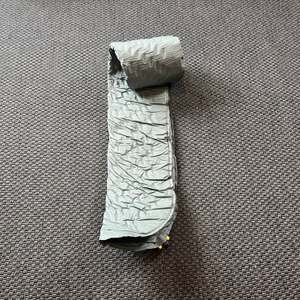 Die Therm-A-Rest Trail Lite liegt halb ausgerollt auf einem Teppich