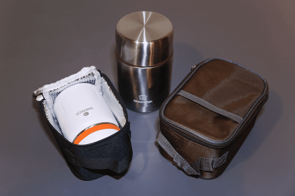 Thermo-Lunchboxen im Test: Auf einem Tisch stehen die beiden getesteten Thermo-Lunchboxen von Santeco und Dreamhigh inklusive ihrer Isoliertaschen.