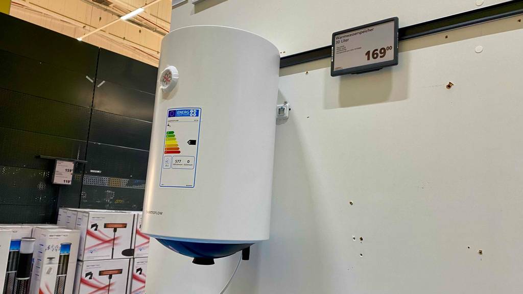 Ein Warmwasserspeicher mit 30 Litern hängt zum testen an einer großen weißen Wand.