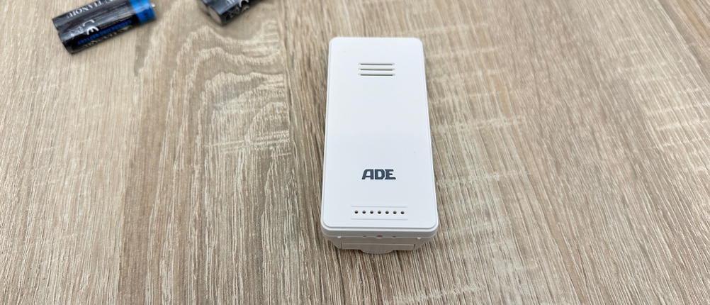 Der Außensensor eines Ade-WS2324-Thermometers liegt separat auf einem Tisch.