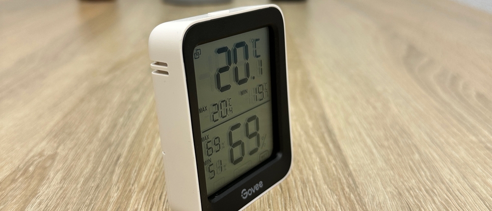 Ein Govee-H5075001DE-Thermometer ist aus einem schrägen Blickwinkel fotografiert und zeigt das Display mit Temperatur- und Feuchtigkeitswerten.